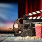 Retro film production accessories placed on wooden planks. Concept of film-making. Red curtain and movie screen on background