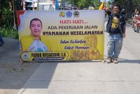 Anggota DPRD Brebes Pamor Wicaksono memasang banner himbauan di ruas jalan Brebes-Jatibarang yang dalam tahap pengerjaan pada Kamis (27/11). Foto: Istimewa