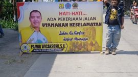 Anggota DPRD Brebes Pamor Wicaksono memasang banner himbauan di ruas jalan Brebes-Jatibarang yang dalam tahap pengerjaan pada Kamis (27/11). Foto: Istimewa