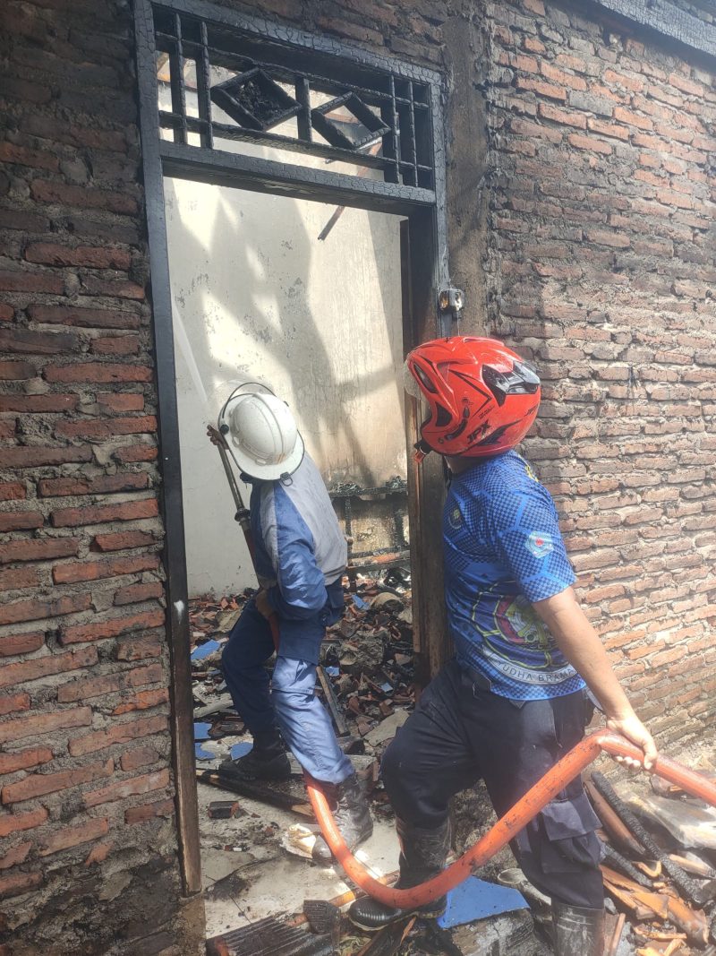Petugas Damkar Brebes sedang mendinginkan sisa kebakaran di bangunan dapur lama rumah milik Warto warga Desa Limbangan, Kecamatan kersana, Brebes pada Senin (15/12). fot: istimewa